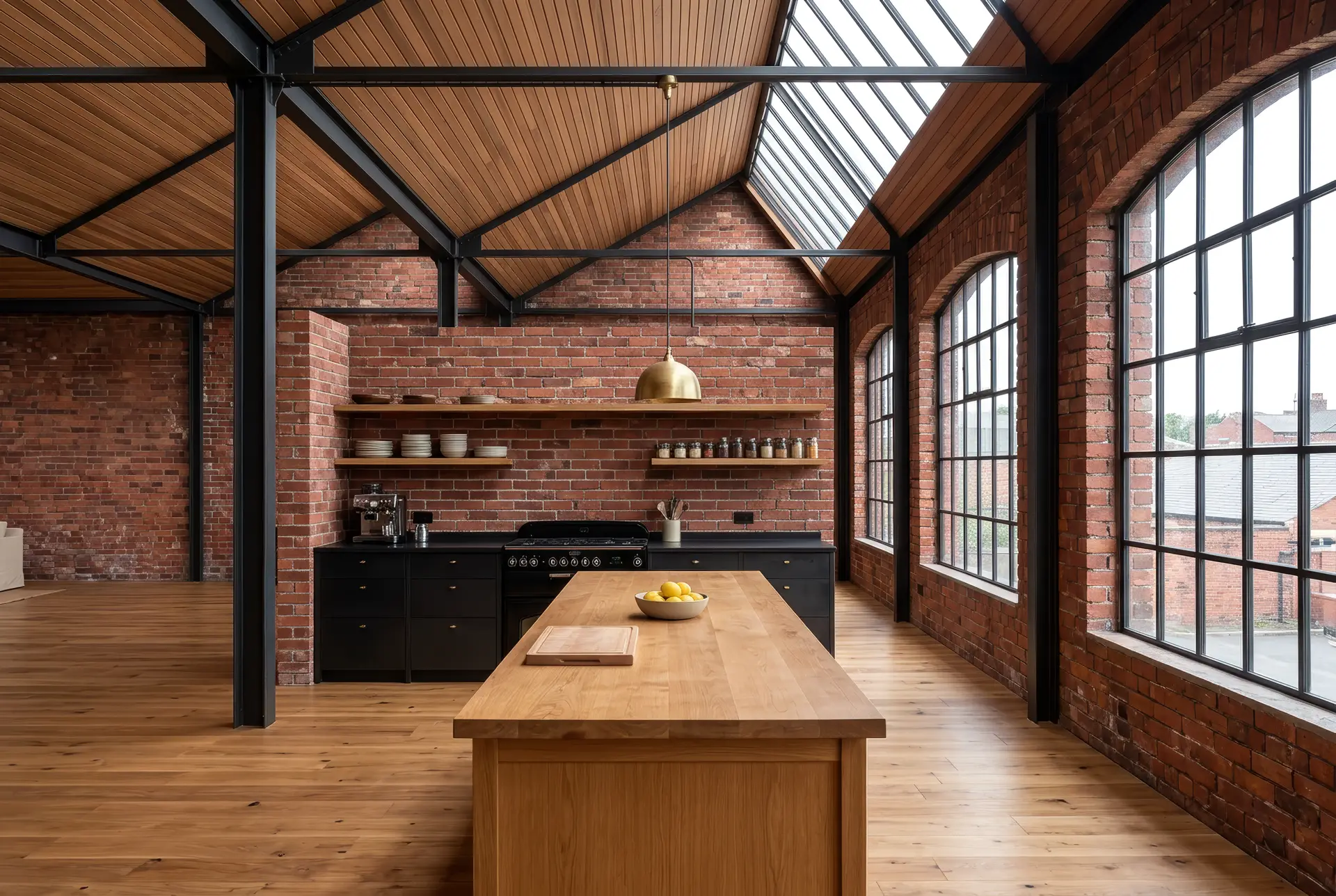 Open keuken in een loft van De Weverij, met een lang eiken kookeiland en een bakstenen muur onder noorderlicht