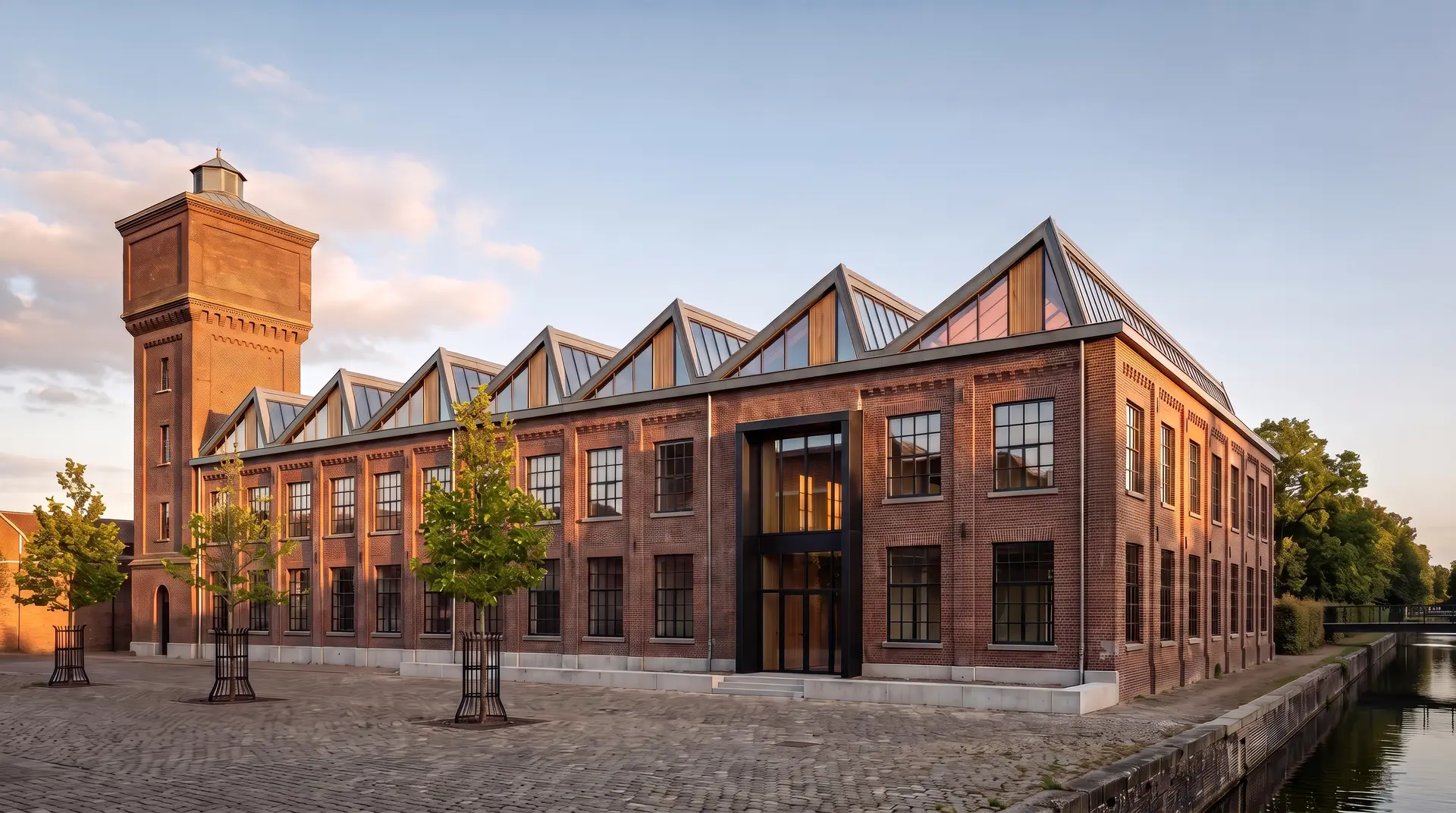 De Weverij, een herbestemde textielweverij met zaagtanddaken en een bakstenen watertoren in licht van de late middag